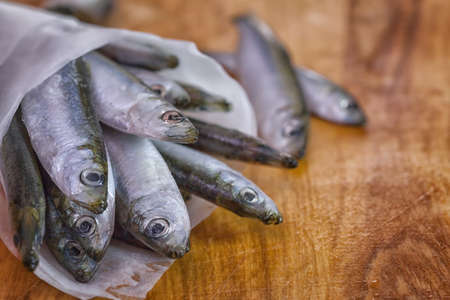 Fresh sardines on wooden board close upの写真素材