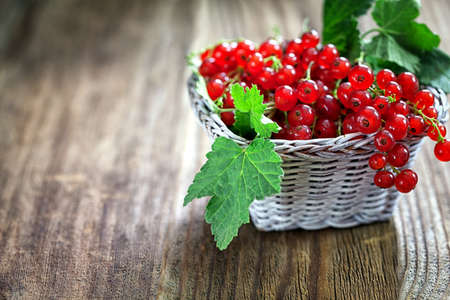 Ripe red currant on wooden background with copy spaceの写真素材