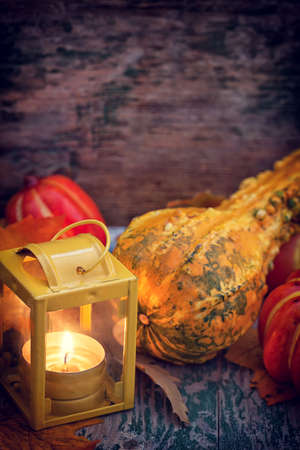 Autumn background with pumpkin and lantern on wooden tableの写真素材