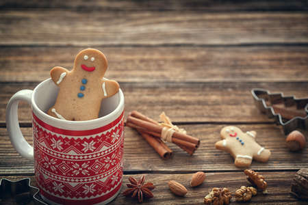 Gingerbread cookie men with mug on wooden background with copy spaceの写真素材
