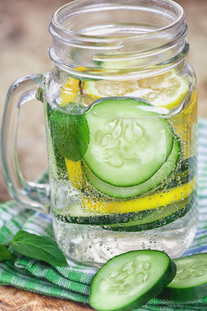 Detox Infused water with cucumber and lemon on wooden backgroundの写真素材