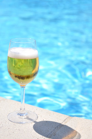 Glass of beer at the swimming pool