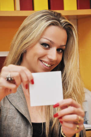 Beautiful woman showing empty paperの写真素材