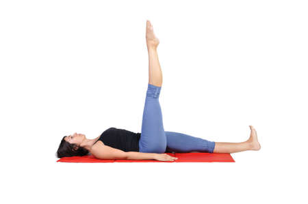 Fit young female pilates instructor showing different exercises on a white background の写真素材