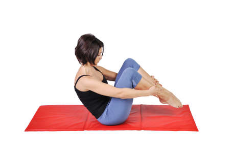 Fit young female pilates instructor showing different exercises on a white background の写真素材