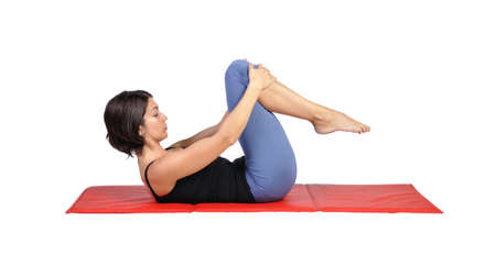 Fit young female pilates instructor showing different exercises on a white background の写真素材