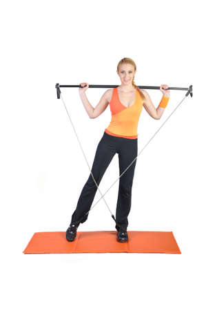 Fit young female pilates instructor showing different exercises on a white backgroundの写真素材