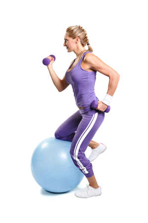 Beautiful muscular woman exercising on a white backgroundの写真素材