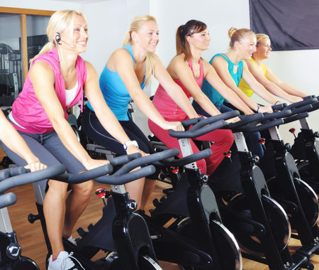 Beautiful women doing exercise in a spinning class at gym