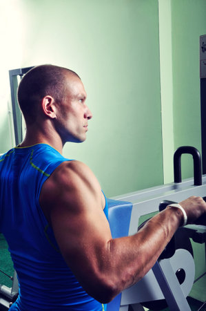 Muscular man exercising in a gym