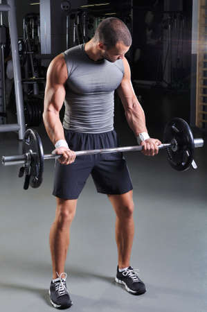 Handsome Muscular Male Model in a Standing Position With Perfect Body Doing Biceps Exerciseの写真素材