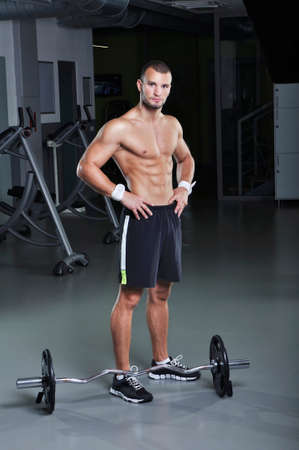 Handsome Muscular Male Model With Perfect Body Posing Next to Barbellの写真素材