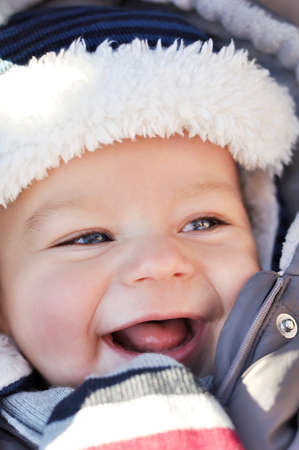 Portrait of smiling cute little baby boy wearing warm winter hat and clothes. Happy child concept.の写真素材