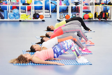 Group of beautiful young women working out at the gym