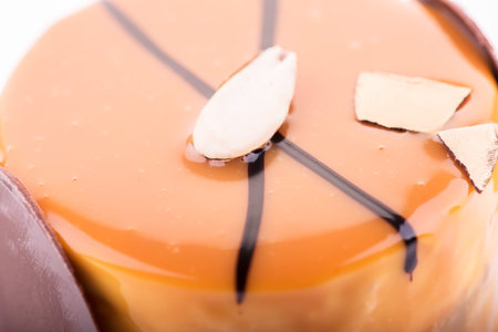 Close up of tasty chocolate cake with almond and orange dressing on the white background.の写真素材