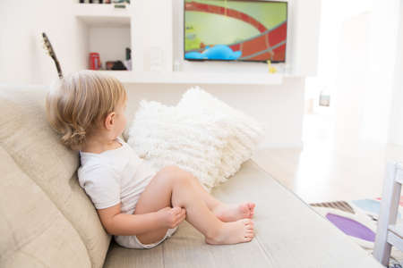 Cute baby boy sitting and watching cartoons.の写真素材