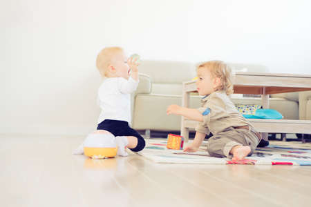 Cute little girl and boy playing with toys at homeの写真素材