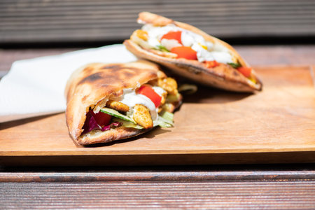 Healthy Grilled Chicken Sandwich with homemade baguette on a wooden plate.