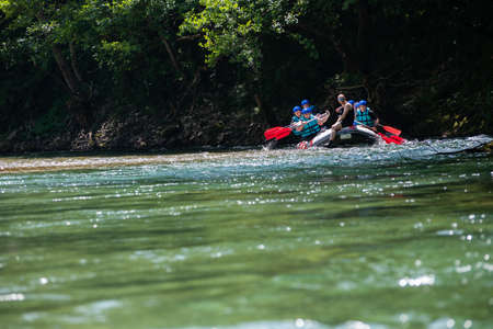 Rafting team goes down the river on the beautiful sunny day.の写真素材