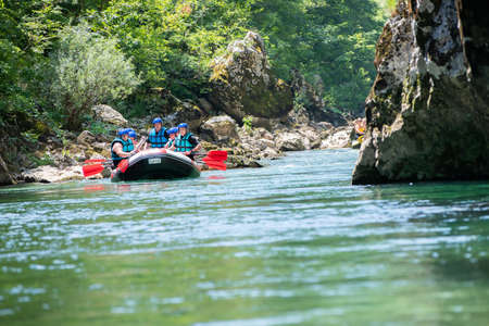 Rafting team goes down the river on the beautiful sunny day.の写真素材