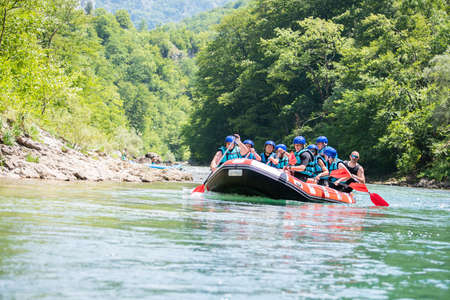 Rafting team goes down the river on the beautiful sunny day.の写真素材