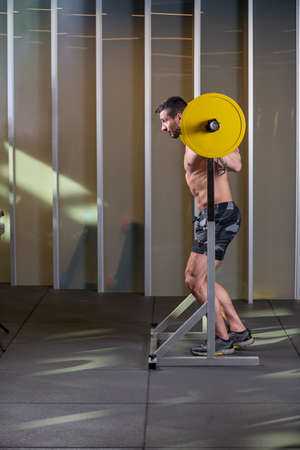 Sexy muscular man doing squat exercise. Side viewの写真素材