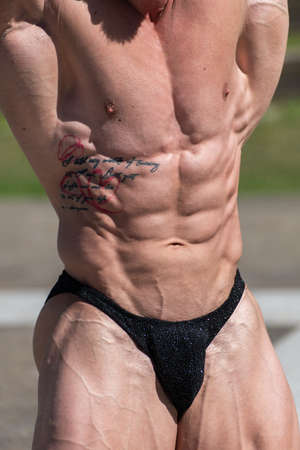 Close up of powerful muscular bodybuilder in panties posing.  Abs contractionの写真素材