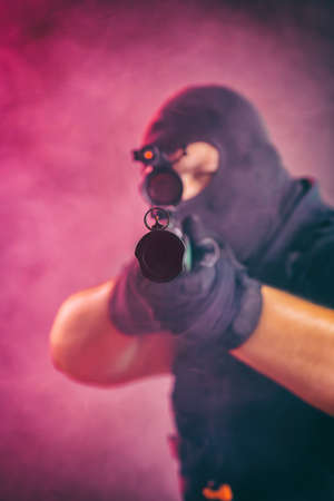 Soldier comes out of the smoke on the battlefield. The concept of military special operations. Aim at the targetの写真素材
