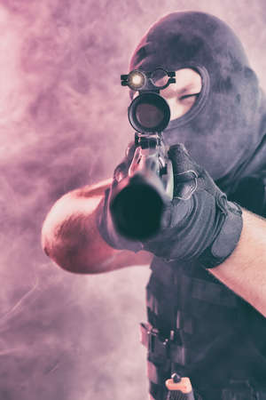 Soldier comes out of the smoke on the battlefield. The concept of military special operations. Aim at the targetの写真素材