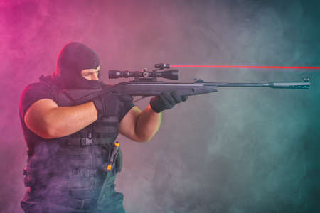 Soldier comes out of the smoke on the battlefield. The concept of military special operations. Aim at the targetの写真素材
