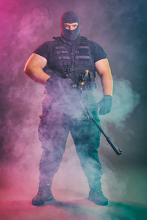 Soldier comes out of the smoke on the battlefield. The concept of military special operations. Standing and posing with shotgunの写真素材