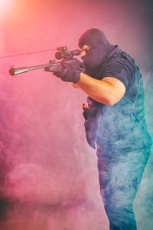 Soldier comes out of the smoke on the battlefield. The concept of military special operations. Aim at the targetの写真素材
