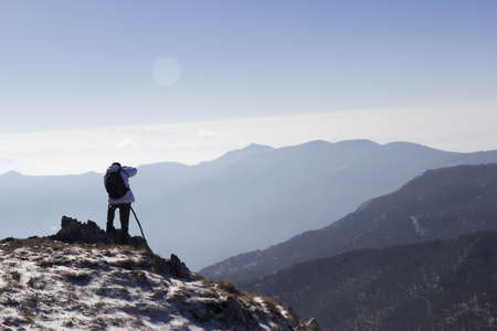 Hiker on the summit of a mountain and snowの写真素材