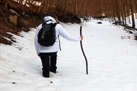 hiker on mountain trail with snowの写真素材