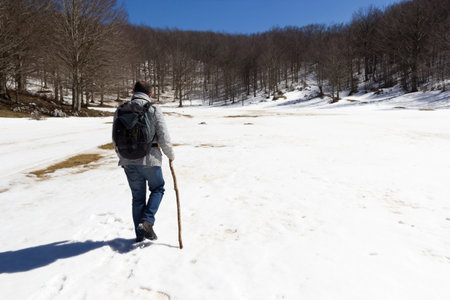 hiker on mountain trail with snowの写真素材