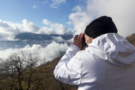 hiker takes picture of a mountain landscapeの写真素材