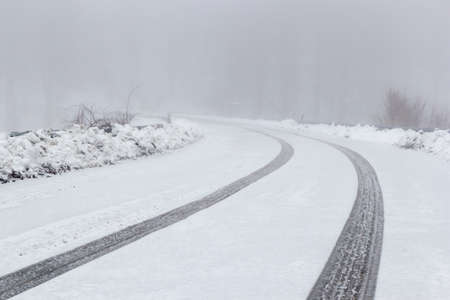 mountain road with fog and snowの写真素材