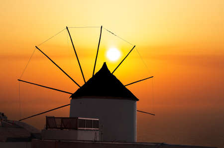 windmill in santorini greece at sunsetの写真素材
