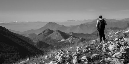 hiker on the top of a mountain in matese park and Letino in the background on Apennines in italyの写真素材