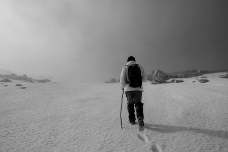 Hiker on the summit of a mountain with snowの写真素材
