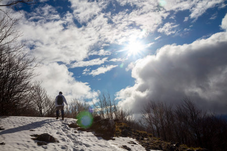 Hiker on the summit of a mountain with snowの写真素材
