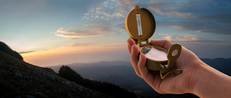 hand with compass and sunset in the mountains for backgroundの写真素材