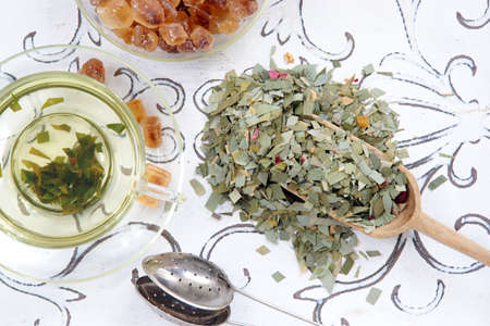 Herbal infusion of lemongrass tea in a glass cup shovel and tea strainerの写真素材
