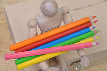 Wood mannequin with crayons on the wooden boxの写真素材