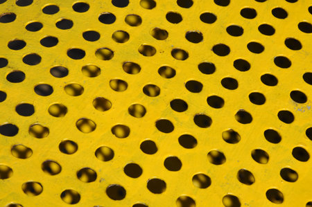 Yellow metal sufrace withe holesの写真素材
