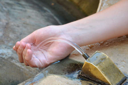 Hand under drinking water fountain の写真素材