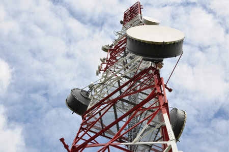 Telecommunication tower with microwave link against a blue sky 