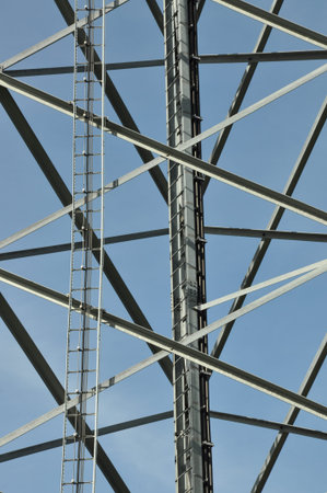 Construction of tower with ladder against blue sky