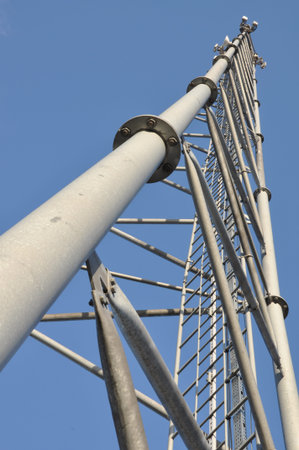 Steel telecommunication tower with antennas over blue sky