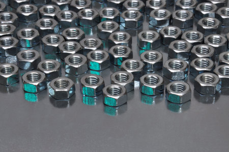 Shiny metal nuts on a metal surface
